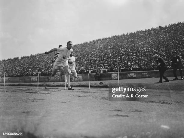 English sprinter Harold Abrahams crosses the finish line in first place to win the Men's 100 yards event at the Amateur Athletics Association...