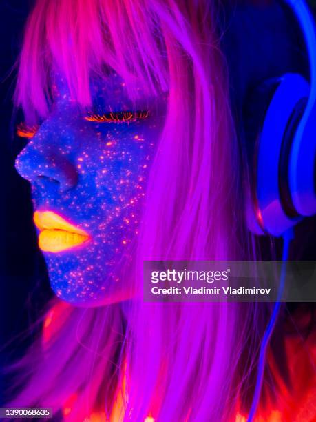 beautiful woman with neon lights enjoying listening to the music - cyber punk girl stock pictures, royalty-free photos & images