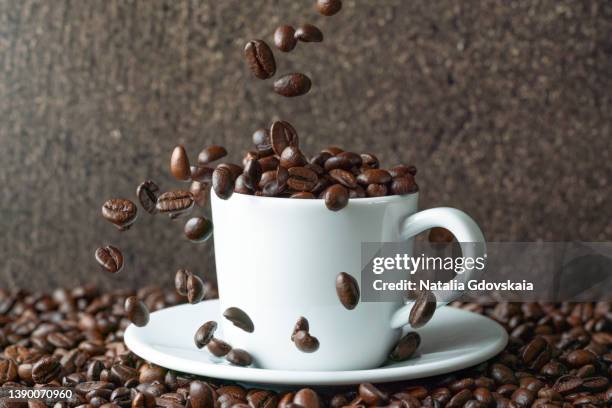 coffee beans falling into white cup. cafe drinkware on pile of arabica scented grains mockup - bean stock-fotos und bilder