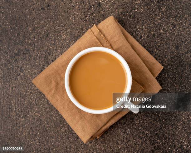 coffee with milk in white ceramic glazed cup on beige napkin from top view copy space - bebida caliente fotografías e imágenes de stock