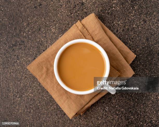 coffee with milk in white ceramic glazed cup on beige napkin from top view copy space - americano photos et images de collection