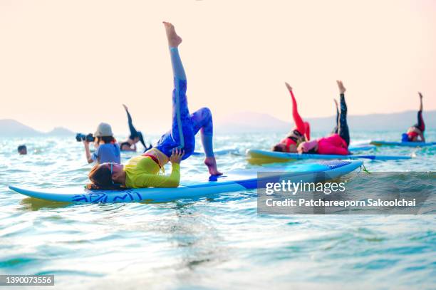 on the water stable - practioners enjoy serenity of paddleboard yoga stockfoto's en -beelden