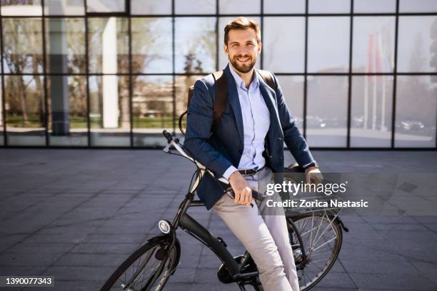 casual businessman with bicycle posing looking at camera - elektrische fiets stockfoto's en -beelden