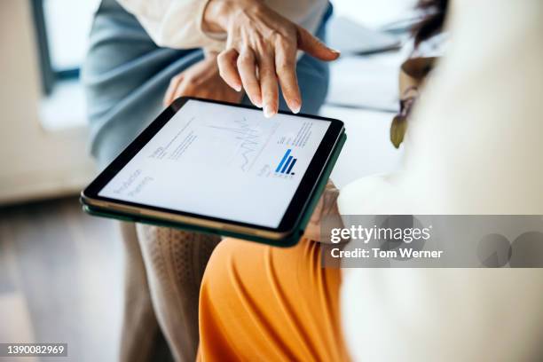 close up of business colleagues using digital tablet together - estrategia de negocio fotografías e imágenes de stock
