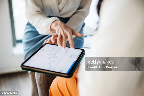 close up of business employee showing manager data on digital tablet - modern business people close up stock-fotos und bilder