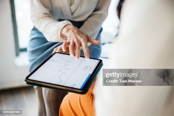 close up of business employee showing manager data on digital tablet - personne ipad main bureau photos et images de collection