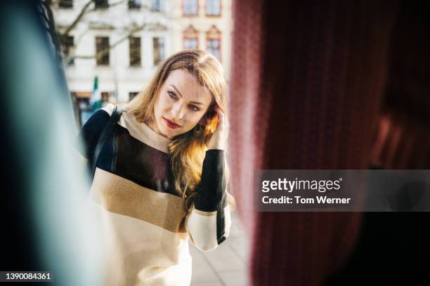 woman looking at retail display from outside store - exclusive dealing stockfoto's en -beelden