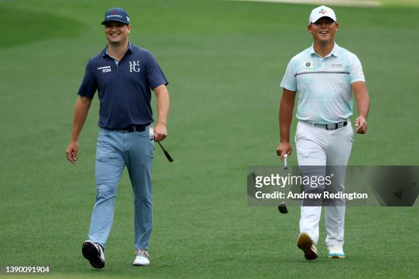 Zach Johnson and Si Woo Kim of South Korea walk across the first hole during the first round of the Masters at Augusta National Golf Club on April...