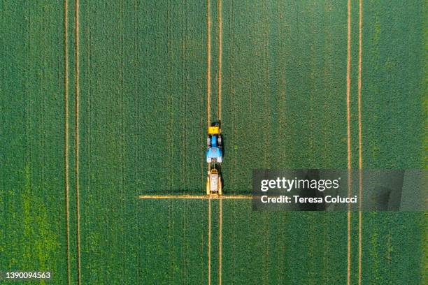 vista aérea del pulverizador de cultivos de tractor agrícola en el campo - abono fotografías e imágenes de stock