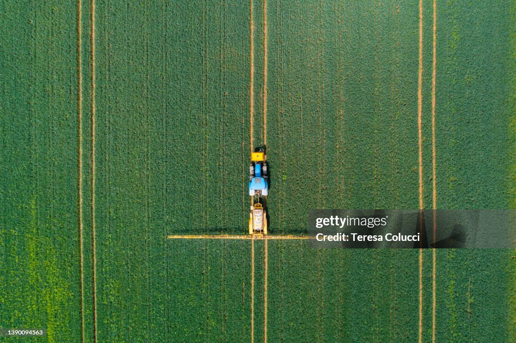 Aerial view of farming tractor crop sprayer in the countryside