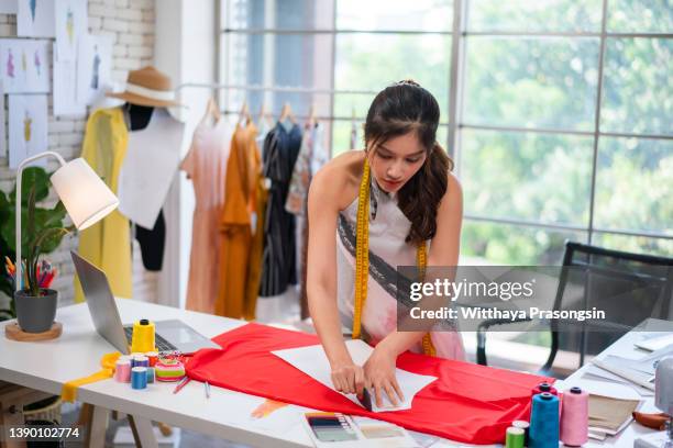 unrecognizable fashion designer cutting fabric in her design workshop, - schnittmuster stock-fotos und bilder