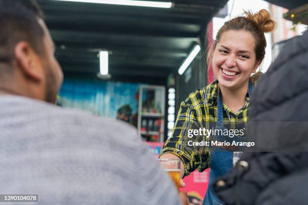 a food truck waitress hands out glasses of beer to customers. - waitress booth stock pictures, royalty-free photos & images