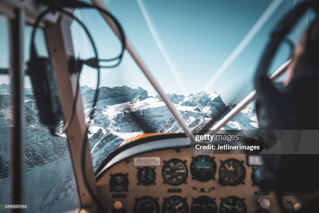 Cockpit view of a historic airplane flying into the mountains