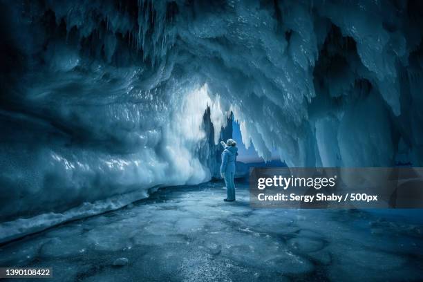 rear view of person exploring ice cave,russia - ice cave imagens e fotografias de stock