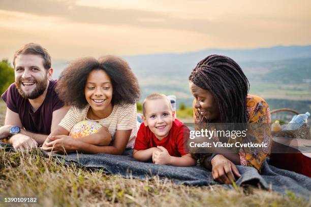 glückliche multiethnische familie, die spaß bei einem picknick hat - couple portrait soft stock-fotos und bilder