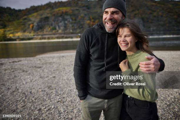 happy father embracing daughter at a riverbank - father daughter 個照片及圖片檔