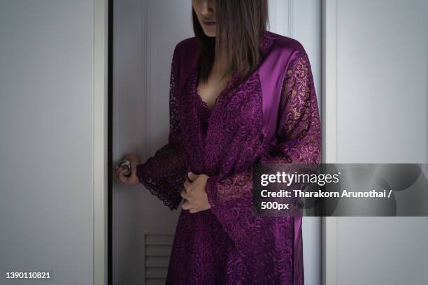 a woman is preparing to sleep in bedroom attire - silk robe stock pictures, royalty-free photos & images