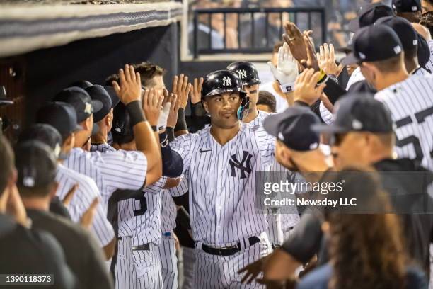 New York Yankees' infielder Giancarlo Stanton celebrates with his teammates in the dugout after hitting a two-run homer in the bottom of the 5th...