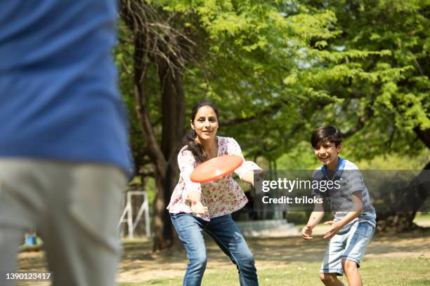 glückliche familie, die mit frisbee-disc spielt - frisbee stock-fotos und bilder