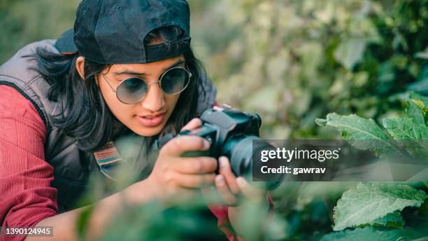 young female photographer shoots in nature. - bent hand stock pictures, royalty-free photos & images