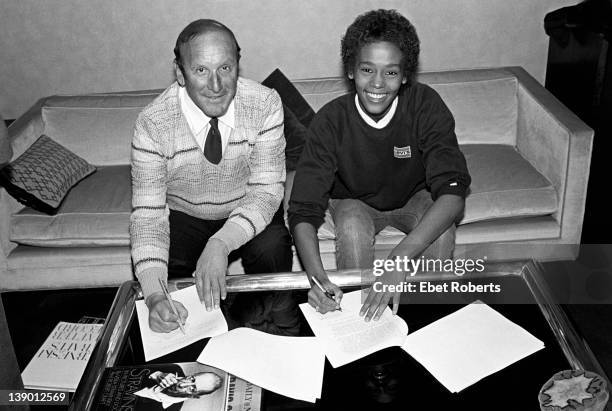 Clive Davis and Whitney Houston photographed at the signing of her contract with Arista Records at the Arista Studio in New York, on April 10, 1983.