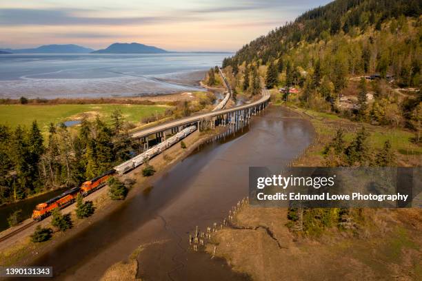 freight train traveling along chuckanut drive in the town of blanchard, washington. - スカジット郡 ストックフォトと画像