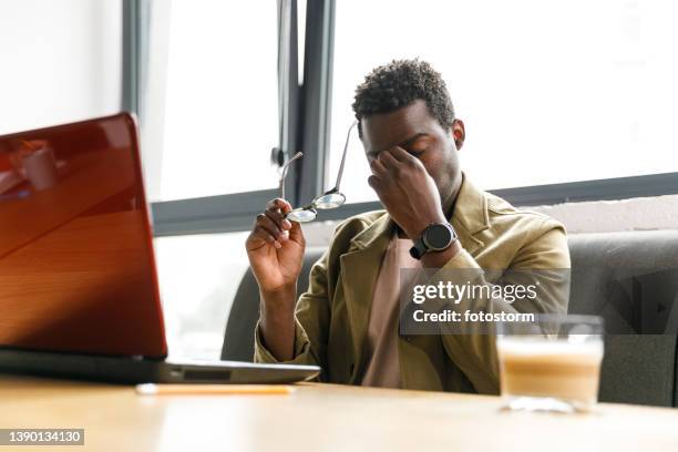 tired businessman rubbing his eyes after taking off eyeglasses - man rubbing eyes stock pictures, royalty-free photos & images