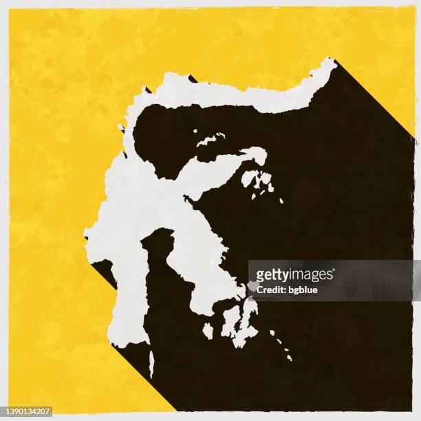 sulawesi-karte mit langem schatten auf strukturiertem gelbem hintergrund - sulawesi stock-grafiken, -clipart, -cartoons und -symbole
