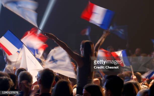 Supporter waves a French flag during an electoral campaign meeting of France's far-right party Rassemblement National leader, Marine Le Pen candidate...