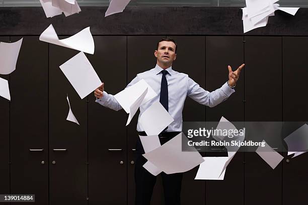 man throws the papers into the air - throwing stock pictures, royalty-free photos & images