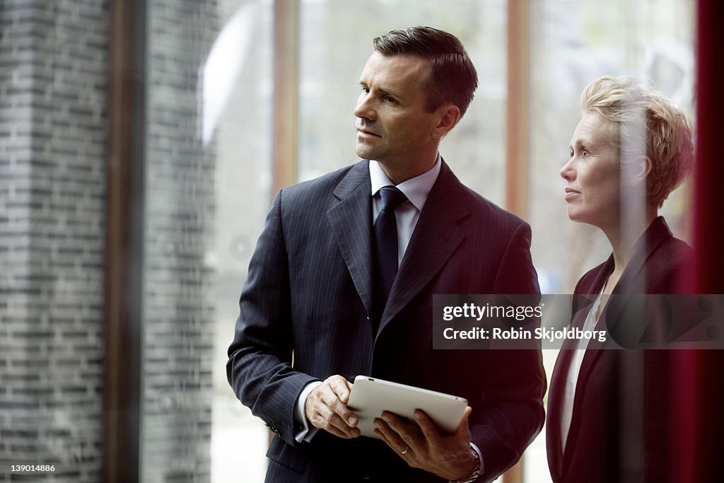 Business man and woman standing listening