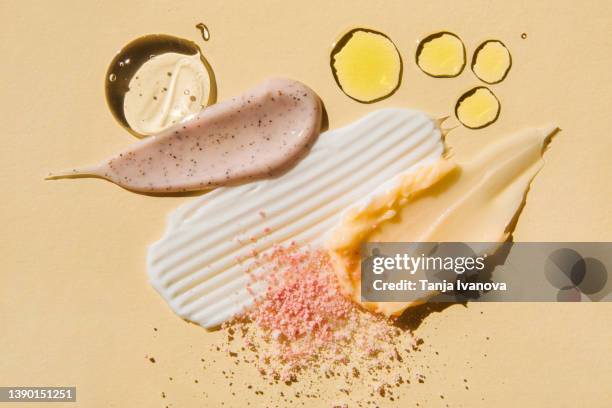 textured multicolored smears cosmetic products on beige background. samples of creams, face gel, scrubs with exfoliating particles, serum. flat lay, top view. - hautpeeling stock-fotos und bilder