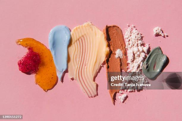 textured multi colored smears of cosmetics on pink background. samples of creams, face mask, scrub with exfoliating particles. flat lay, top view. - body scrub stock-fotos und bilder