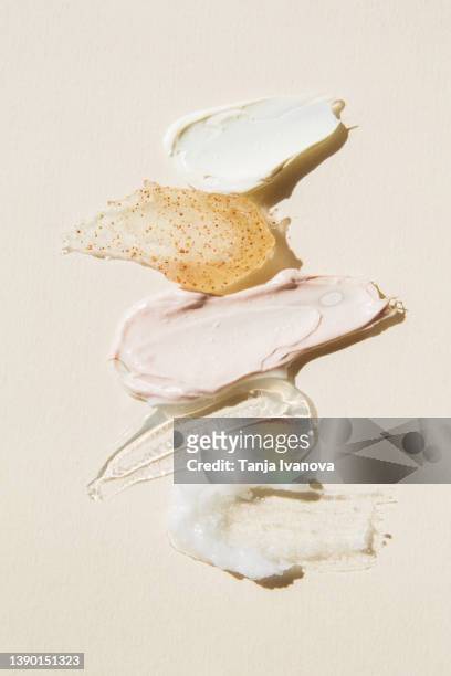 textured multi colored smears of cosmetics on a beige background. samples of creams, face mask, scrub with exfoliating particles, face gel, serum. flat lay, top view. - beauty product - fotografias e filmes do acervo