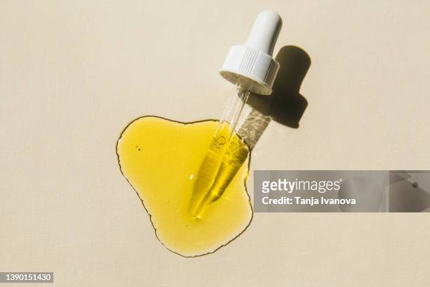 pipette with cosmetic liquid on beige background. beauty product with peptides, ceramides, polyglutamic acid, essential oil, cbd, retinol. multitasking beauty. flat lay, top view. - jojoba oil stock pictures, royalty-free photos & images