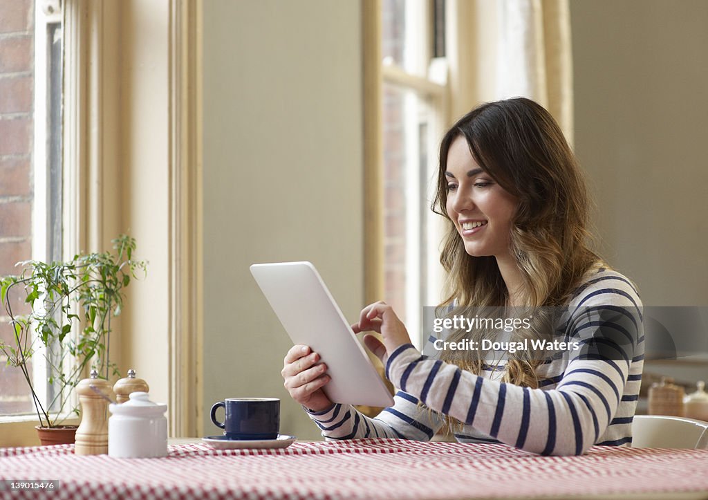 Student in cafe using digital tablet.