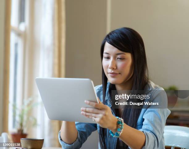 asian student in cafe using digital tablet. - nepalese ethnicity - fotografias e filmes do acervo