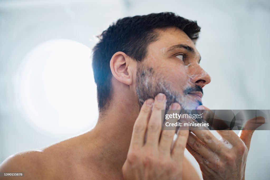 Handsome Man Washing his Face in the Bathroom