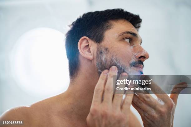 handsome man washing his face in the bathroom - beard care stock pictures, royalty-free photos & images