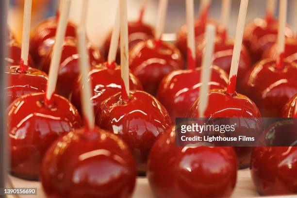 cu. rows of delicious red candy apples - fête foraine photos et images de collection