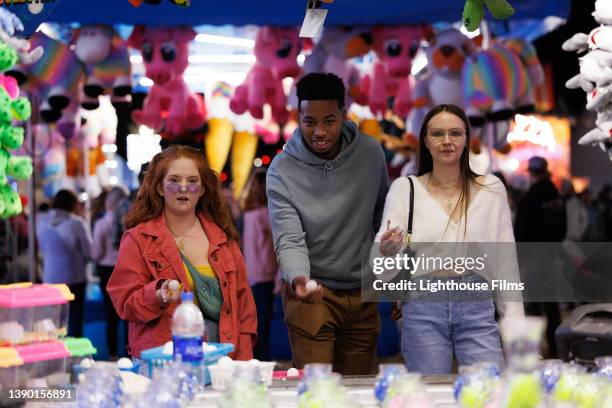 three people play carnival fishbowl game - fete fotografías e imágenes de stock