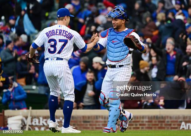 Pitcher David Robertson and Willson Contreras of the Chicago Cubs celebrate after securing a 5-4 win over the Milwaukee Brewers on Opening Day at...