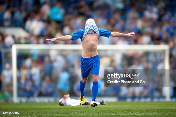 football player rejoicing, shirt over head - rete di calcio foto e immagini stock