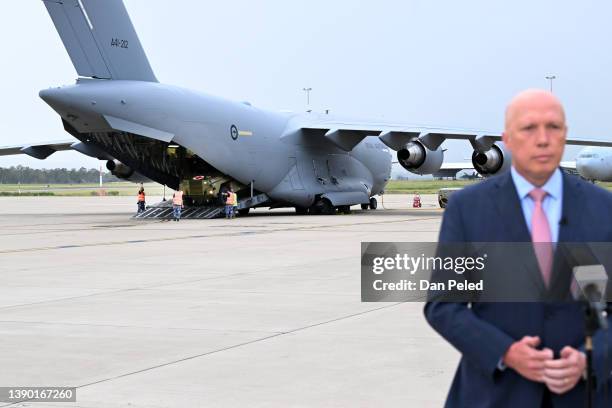 An Australian Bushmaster PMV Armoured Vehicle is loaded onto a RAAF C-17 cargo plane as Australian Defence Minister is doing a TV interview at the...