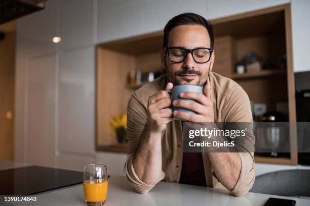 young man drinking his morning coffee at home. - man having tea stock pictures, royalty-free photos & images