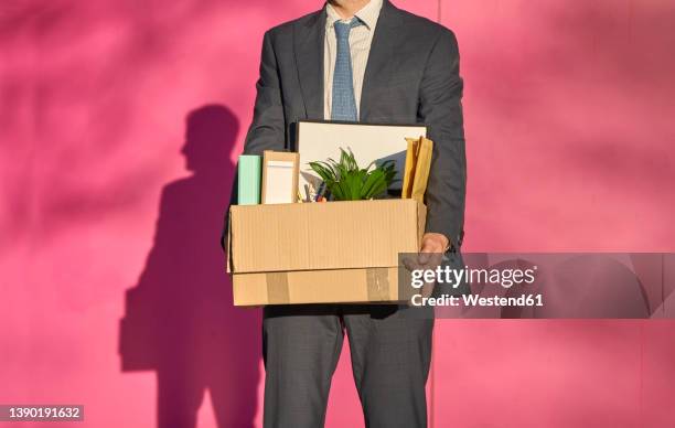 businessman carrying box with personal belongings on sunny day - downsizing unemployment stock pictures, royalty-free photos & images