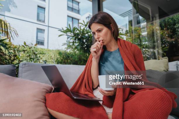 sick businesswoman coughing and working on laptop in yard - husten stock-fotos und bilder