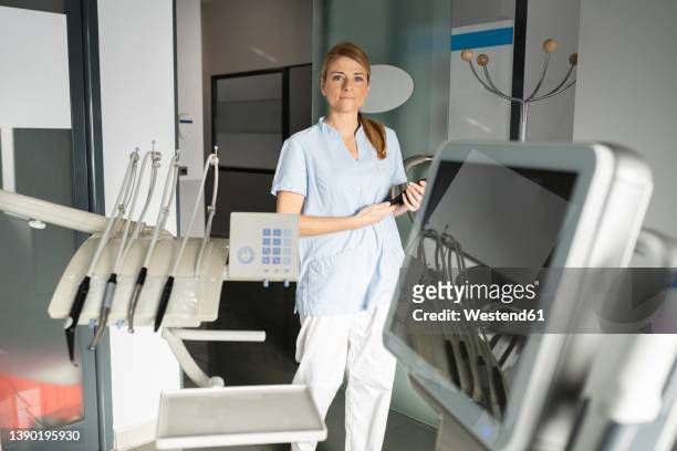 dentist with tablet pc walking in dental clinic - dental office front stock pictures, royalty-free photos & images