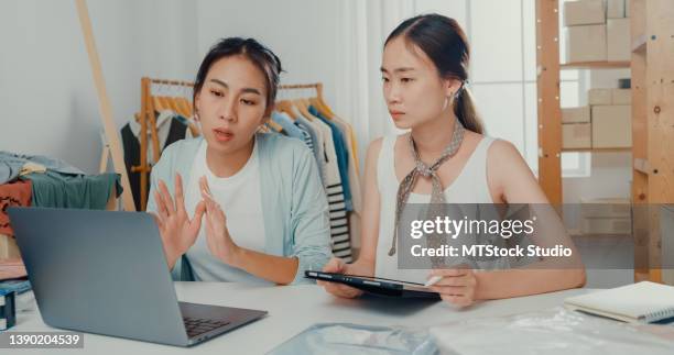 upset young asian women with laptop and tablet meeting check stock prepare order and plan shipping to customer at shop. - product development stockfoto's en -beelden