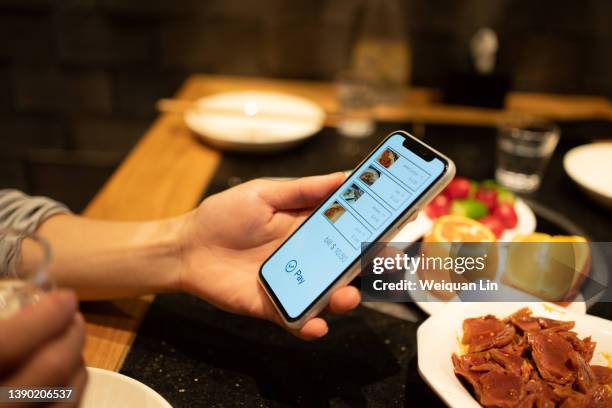 asian man using smartphone to order food - meal expense stock pictures, royalty-free photos & images